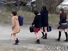 Four Japanese schoolgirls loser around outside before peeing