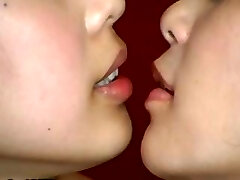 Two Japanese girls are doing some weird kissing with a jaws speculum
