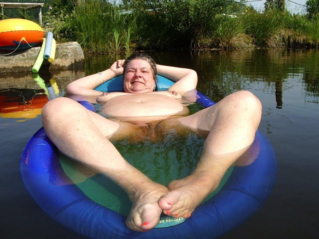 Fat mature nudist women swimming in a pool