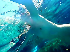 ein russisches mädchen mit einem atemberaubenden körper schwimmt mit goldlehrern