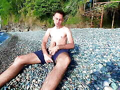 Guy jerking off dick on a nudist beach and a passerby joined him