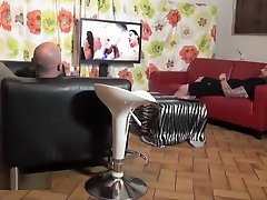 Deux pervers se tapent la femme de menage dans le salon apres avoir regardé un film porno sur lécrant geant.