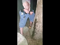 trans guy peeing on a tree