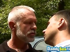 Horny stud fucks mature man in missionary pose in public