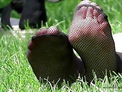 Feet in fishnets socks on the grass