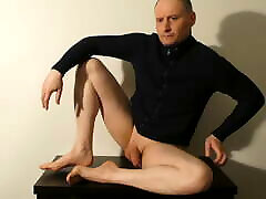 Kudoslong posing on a table in a jacket his flaccid penis is shaved smooth. He starts masturbating and is soon erect