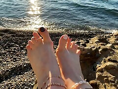 mistress lara gioca con i suoi piedi e le dita dei piedi sulla spiaggia