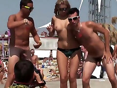 Naked guys on the beach have fun with a young girl