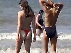 Two young blonde chicks walking on the sunny with husbend beach topless