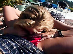 Redhead and blonde MILF having lesbo fun by the pool