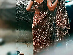 The desi sister-in-law of the village opened the drenched saree and took a bath in the open bathroom.