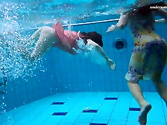 Two saucy lassies remove their clothes under the water